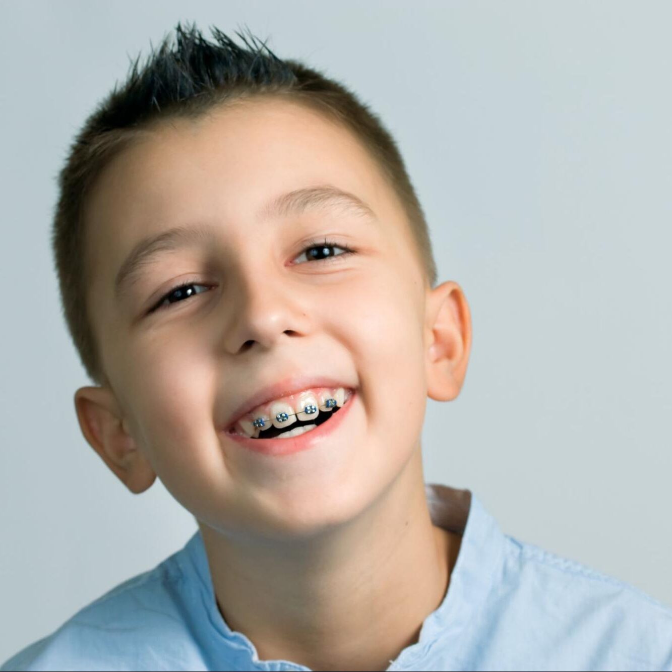 Smiling boy with metal braces showcasing a confident smile, representing orthodontic care at Shine Pediatric Dentistry & Orthodontics for kids in Hendersonville.